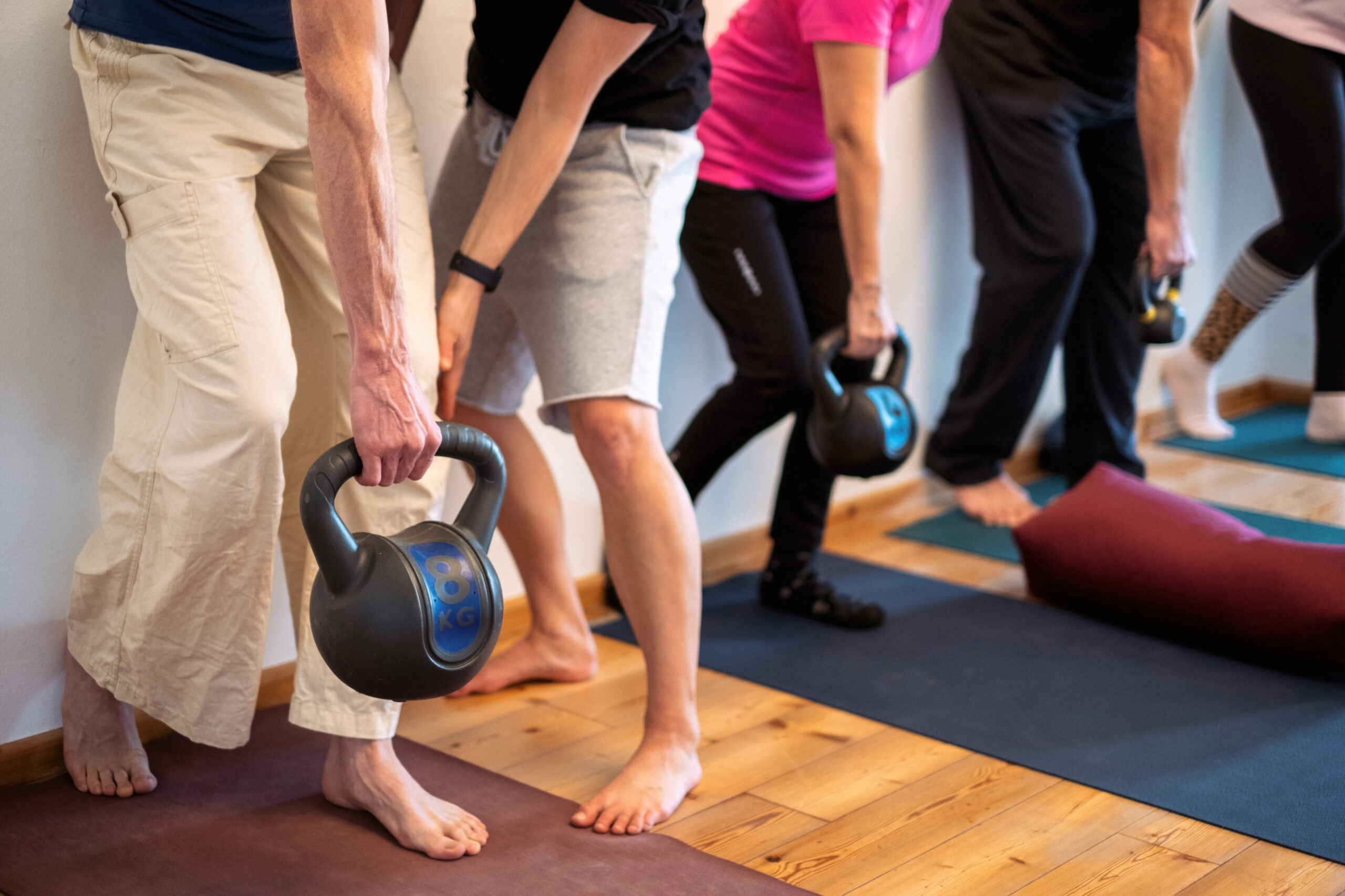 Gruppe beim Training mit Kettlebell in der Hand.